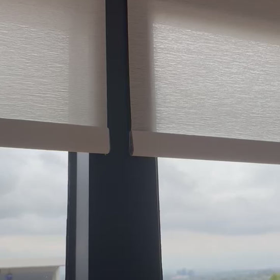 Custom motorized light-filtering roller shades installed in a living room
