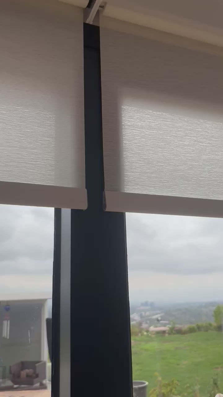 Custom motorized light-filtering roller shades installed in a living room
