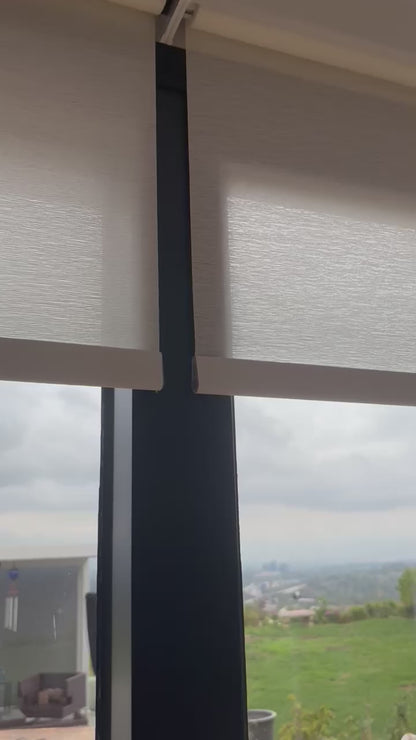 Custom motorized light-filtering roller shades installed in a living room