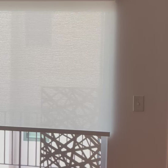 Manual chain-pull light-filtering roller shade being lowered