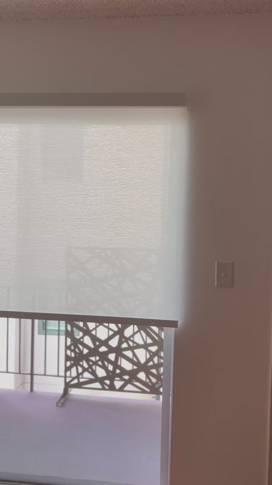 Manual chain-pull light-filtering roller shade being lowered